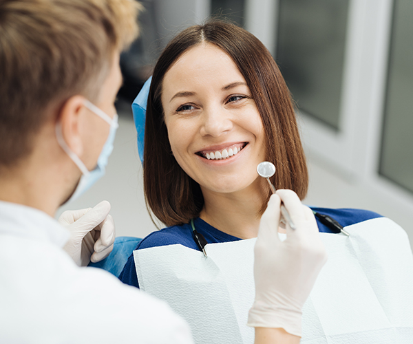 Male Professional Dentist With Gloves And Mask And Discuss What The Treatment Will Look Like Of The Patient's Teeth. Discussion Of The Treatment Plan And Healthy Smile