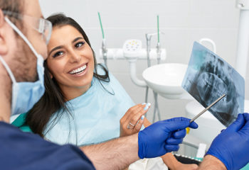 people, medicine, stomatology and health care concept - happy male dentist showing work plan to woman patient at dental clinic office.