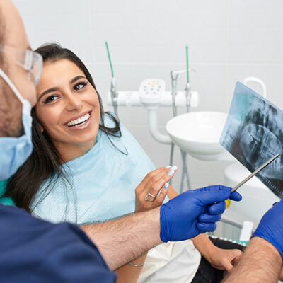 people, medicine, stomatology and health care concept - happy male dentist showing work plan to woman patient at dental clinic office.