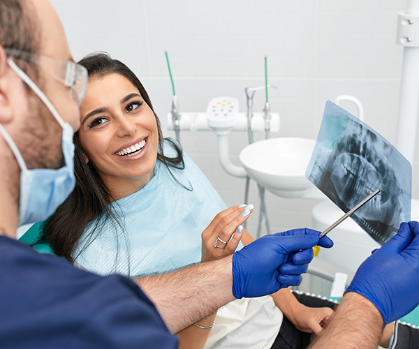 people, medicine, stomatology and health care concept - happy male dentist showing work plan to woman patient at dental clinic office.